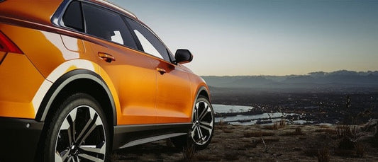 Orange SUV Against Sunset Background